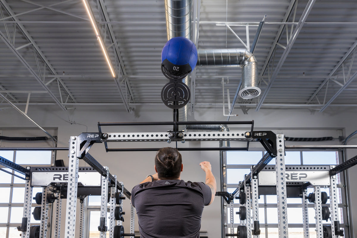 Athlete doing wall balls on the REP Fitness Crossmember Mount Wall Ball Target